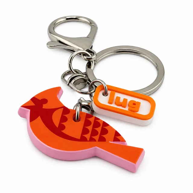 A red and orange cardinal key chain with a silver ring and orange Lug charm.