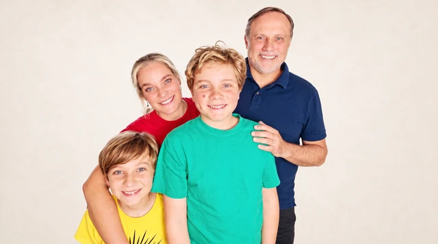 The four members of the US4 family smiling together.