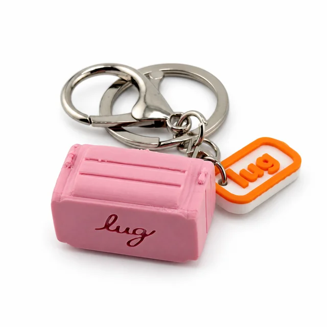 A pink miniature Lug trolley bag key chain with a silver ring and orange Lug charm.