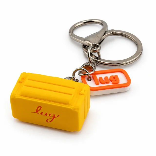 A yellow miniature Lug trolley bag key chain with a silver ring and orange Lug charm.